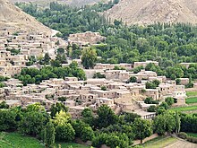 تصویری مشرف به روستای طبس که از ارتفاعات مجاور انداخته شده و خانه‌های روستایی و درختان و کوه‌ها را نشان می‌دهد.