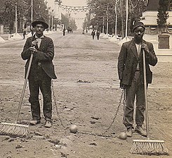 A photo postcard of prisoners sweeping the streets (1909)