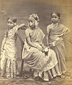 The girl on the left is wearing the langa voni. The other two are wearing saris. The jewelled head-dress of the girl in the center is traditionally worn at marriage ceremonies or at rite-of-passage ceremonies performed when a girl reaches puberty. Tamil Nadu, c. 1870.