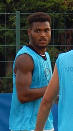 Photographie d'un joueur de football avec un chasuble bleu.