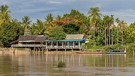 Berge de l'île de Don Khon avec des maisons en bois sur pilotis et des pirogues, vue depuis Don Det