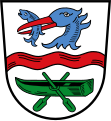 Gemeinde Rottach-Egern In Silber ein roter Wellenbalken; oben der Rumpf eines blauen Fischreihers mit blauem Fisch im roten Schnabel, unten ein grüner Kahn mit zwei Rudern.