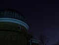 Observatoriumskuppel mit dem Sternbild Orion im Hintergrund.