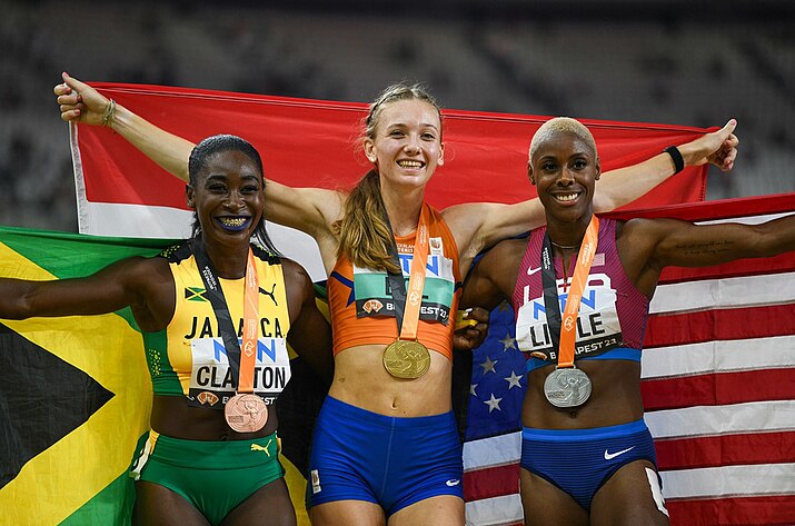 Rushell Clayton wearing a yellow-green-black sleeveless top and having a bronze medal around her neck