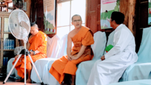 A Buddhist monk talking to a Catholic priest in a temple in Kanchanaburi A Thai monk talks to a papa.png