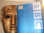 BAFTA (British Academy of Film and Television Arts) mask and the BBC logo. The BBC broadcasts BAFTA's film and television award ceremonies. BAFTA Mask and BBC Logo (2008).jpg