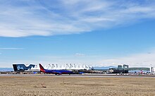 Боинг 737-800 Southwest Airlines рулит на север, за ним находятся отель Westin в аэропорту, терминал Jeppesen и воздушный мост к залу A.