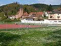 Ortsbild mit Sportplatz und katholischer Kirche
