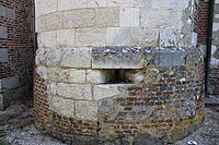 Meurtrière à hauteur d'homme au bas d'une tour.