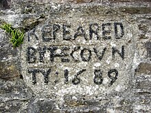 A stone plaque reading REPEARED BY THE COUTY: 1689