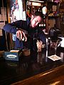 Pacific Standard owner Jonathan M. Stan at the bar, beginning to prepare the Santorum cocktail drink. He is shown here pouring Baileys Irish Cream into a tall glass with ice.
