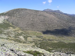 Vista de la vertiente suroeste del Cerro de Valdemartín. Tras esta montaña se ven las Cabezas de Hierro.
