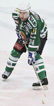 Zigmund Palffy in a full hockey uniform holding his stick out on the ice rink