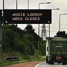 A sign on the M25 London orbital road warns drivers to avoid the city. AvoidLondon77.jpg