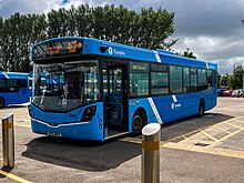 A two-tone blue single deck bus parked at a bus stop.