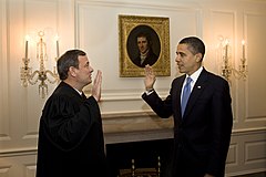 Obama (right) faces man in judge's robe as they raise their right hands