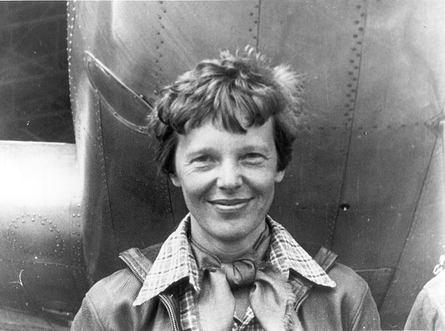 Amelia Earhart standing next to her aircraft