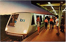 A postcard of a rapid transit train at a station, with passengers in typical 1970s clothing