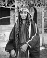 A Bedouin woman in traditional attire, c. 1898-1914. Bedouin in the Sinai wore apparel modified for the desert environment, usually cotton, poplin, or sateen. Black was the preferred fabric color. Sinai and Negev Bedouin women used the same brightly colored embroidery cross-stitch used throughout Palestinian villages. Embroidery indicated a woman's marital status: blue for unmarried women and red for married women.