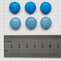 Photograph of blue NestlÃ© Smarties as sold in the UK, before (top, dating from 2006) and after (2008, bottom) change to natural colours. Background is 1mm grid.