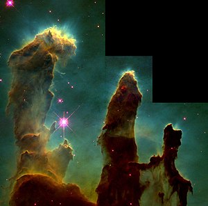 鷹星雲中三個氣柱的哈伯照片。圖像右上角的一些黑色的正方形是黑色的，不包含任何內容。