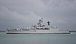 Long, grey ship against a cloudy sky