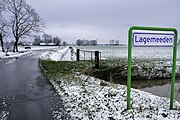 Naamsbordje gezien vanaf Den Horn met de begraafplaats op de achtergrond (midden achter)