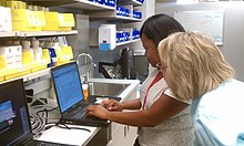 Pharmacists filling prescriptions at a computer