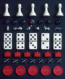 A selection of pieces from different games. From top: Chess pawns, marbles, Monopoly tokens, dominoes, Monopoly hotels, jacks and checkers pieces. Game pieces.jpg