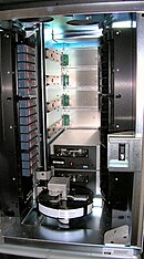 Small ADIC Scalar 100 tape library, showing a robot visible on the bottom with two IBM LTO2 tape drives behind it ADIC Scalar 100 tape library.jpg