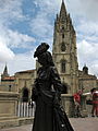 Vista de la estatua de La Rexenta (1997) cola catedral uvieína al fondu.