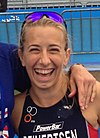 Sarah Reinersten wearing blue-tinted sunglasses on top of her head and smiling widely