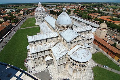 Catedral de Pisa vista a partir da "torre inclinada" revela a forma de cruz latina, com uma abside pronunciada no primeiro plano e um batistério isolado no lado oeste.