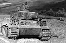 A black and white photo of the Tiger I tank with a soldier inside it, landscape, vegetation on the background