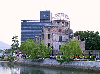 Граѓаните на градот минуваат покрај Споменикот на мирот во Хирошима на пат кон церемонија на спомен на 6 август 2004 година