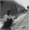 In the village of Niono, a native prepares thread - spun from locally-grown cotton - for weaving, ca. 1950.