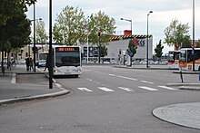 Photo avec un bus à l'arrêt dans la gare routière.