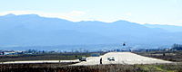 Gjakova Airfield RWY 17 with an ongoing NATO touch and go helicopter practice.JPG