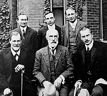 Front row: Sigmund Freud, G. Stanley Hall, Carl Jung]. Back row: Abraham A. Brill, Ernest Jones, Sandor Ferenczi at Clark University in 1909. Hall Freud Jung in front of Clark.jpg