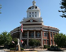 Photo d'un grand bâtiment avec une horloge et un drapeau des États-Unis.