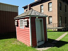 Picture of outhouse with School in background