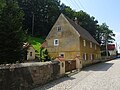 Wohnstallhaus, mit Anbau im Winkel, sowie Handschwengelpumpe im Hof und seitlicher Mauereinfriedung