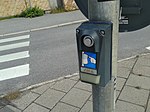 Knapp för fotgängare att påkalla grön signal vid ett bevakat övergångsställe, Linköping.