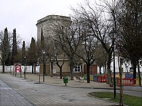 Town streets and trees with a square tower in the background