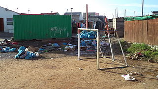 A dilapidated football playing field in Joe Slovo Park, filled with debris