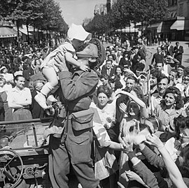 Բանակային ֆիլմերի և լուսանկարչության միության լրագրողը համբուրում է մի երեխայի՝ ուրախացնելով Փարիզի բազմությանը, 1944, օգոստոս 26։