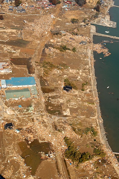 An aerial view of tsunami damage in an area north of Sendai, Japan, taken from a U.S. Navy helicopter. слика: -{U.S. Navy}-.