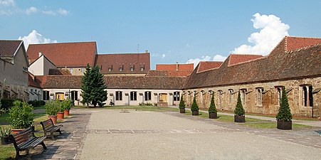 Photographie d'une cour vide entourée d'un cloître.