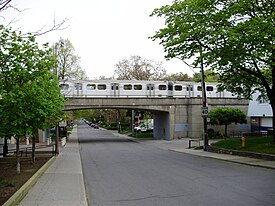 A subway train crosses Clendennan Avenue, a residential road in High Park North