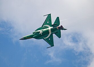 Ein fliegender Kampfjet zeigt im Kurvenflug seine Unterseite, die als Pakistanische Flagge gestaltet ist